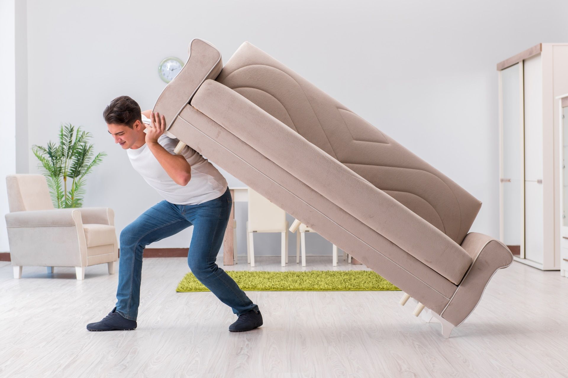 Mann hebt ein großes Sofa beim Umzug an
